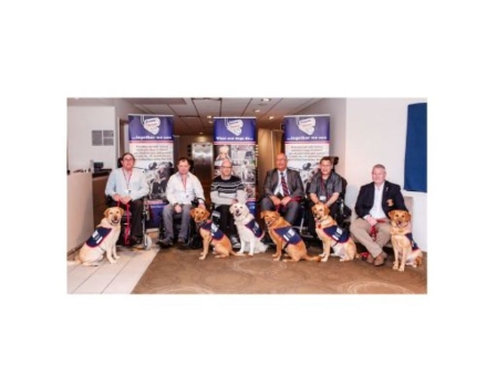 6 men sat with their assistance dogs