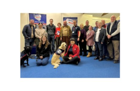 Group shot of some of our supporters with two assistance dogs sat at the front