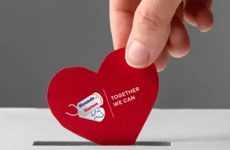 Heart-shaped Hounds for Heroes logo being posted, representing support through payroll giving